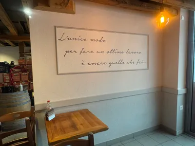 Stilvolle Wandgestaltung in einem Restaurant in Winterthur mit italienischem Spruch und warmem Licht – frisch gestrichen und elegant ausgeführt vom Malerbetrieb in Winterthur.
